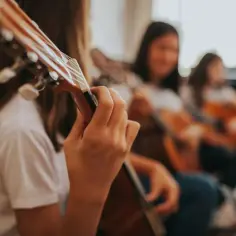 Dziewczyny ćwiczą grę na gitarach, ucząc się, do której klasy jest muzyka.
