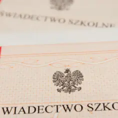 Zbliżenie na świadectwo szkolne z godłem Polski. Pasek z czerwonym i białym pasem sugeruje, że jest to dokument oficjalny, od jakiej średniej jest pasek?