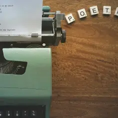 Maszyna do pisania z wierszem o papierowym ptaku i kostki z napisem POETRY. To nic dwa razy interpretacja wolności.