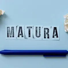 Napis "MATURA" na niebieskim tle, obok kulki papieru i długopis. Zastanawiasz się, ile trwa matura z polskiego?