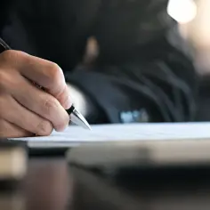 Dłoń pisze piórem po papierze, póki nie skończy.