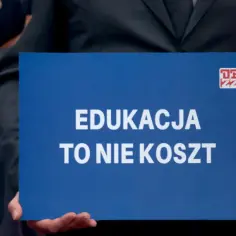 Nauczyciele domagają się podwyżek, trzymając transparent "Edukacja to nie koszt".