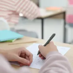 Uczeń pisze test, zastanawiając się, ile jest punktów na maturze z matematyki.