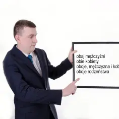 Mężczyzna w garniturze pokazuje tablicę z napisami: "obaj mężczyźni", "obie kobiety", "oboje, mężczyzna i kobieta", "oboje rodzeństwa".