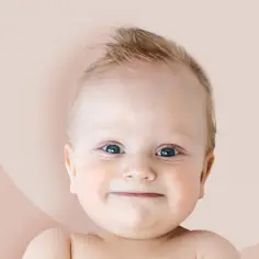 Uśmiechnięta buzia dziecka, idealna dla Amelii czy Amelii, z niebieskimi oczami i blond czuprynką.