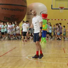 Trener z mikrofonem i dzieci w hali sportowej. Czy uda się znaleźć wszystkich uczestników?