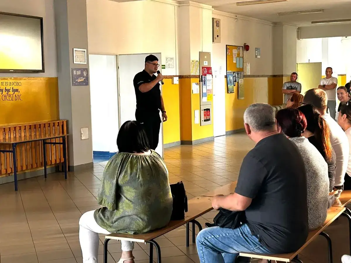 Policjant przemawia do rodziców i uczniów. Dowiedz się, gdzie zgłosić nękanie dziecka w szkole.