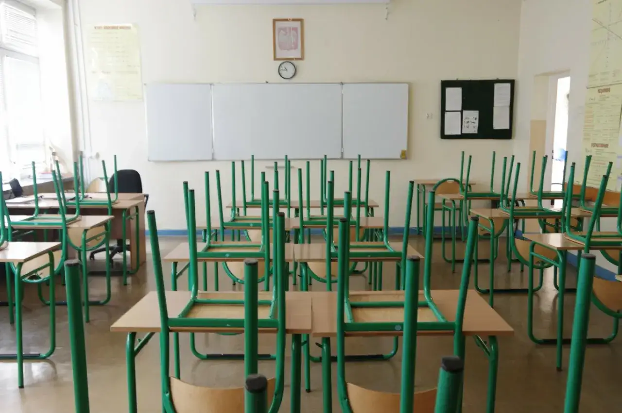 Puste ławki i krzesła w sali lekcyjnej. Widać tablice, zegar, plakaty edukacyjne. Takie przedmioty są w siódmej klasie.