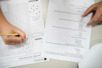 Ręka zaznacza odpowiedź na arkuszu z pytaniami do matury z biologii. Ile trwa matura z biologii? To pytanie nurtuje wielu uczniów.